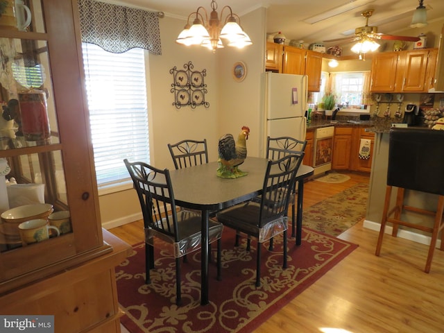 dining room with ceiling fan with notable chandelier, light hardwood / wood-style floors, and crown molding