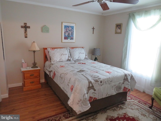 bedroom with ornamental molding, wood-type flooring, and ceiling fan