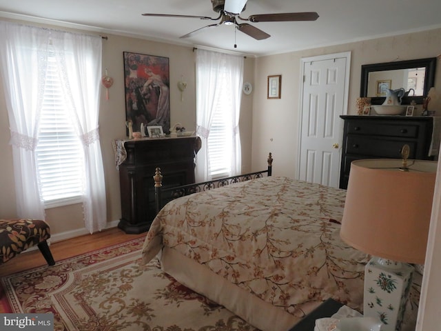 bedroom with hardwood / wood-style floors, ceiling fan, and crown molding