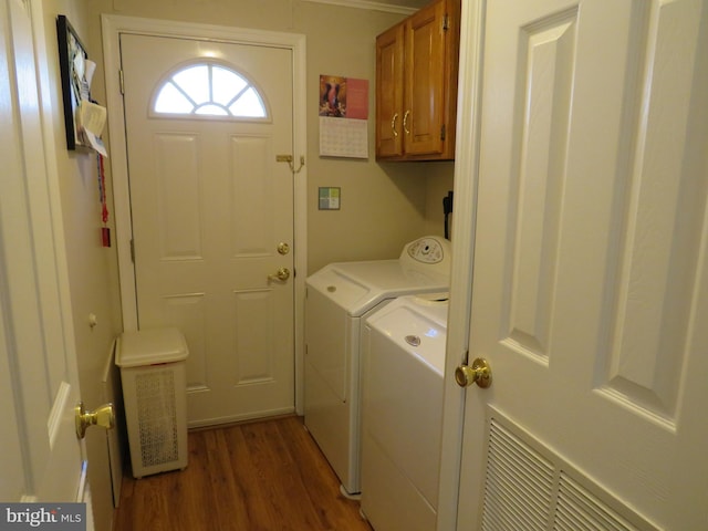 laundry room with cabinets, dark hardwood / wood-style flooring, and independent washer and dryer