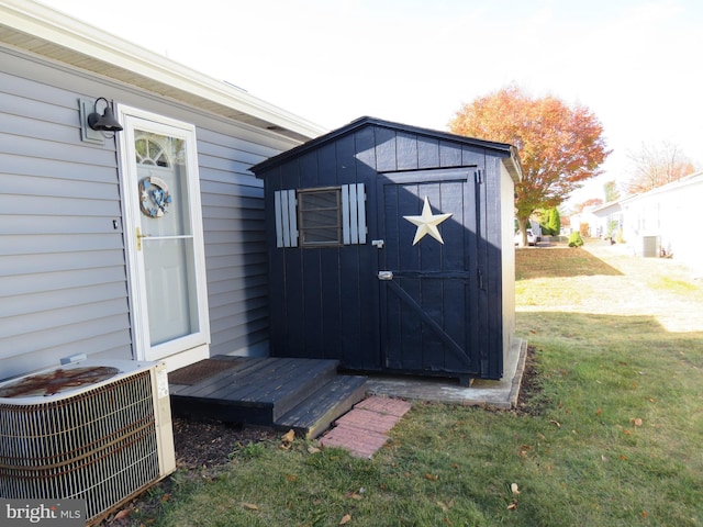 view of outdoor structure featuring central AC and a lawn