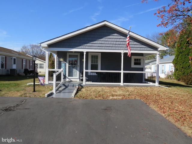 bungalow featuring a front lawn, central AC unit, and a porch