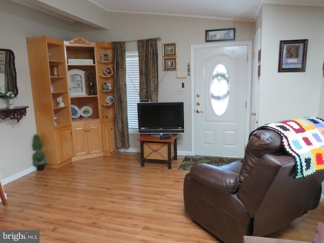 living room featuring light hardwood / wood-style floors, crown molding, and vaulted ceiling