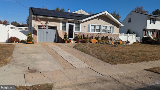 view of front of property with a front yard, solar panels, and a garage