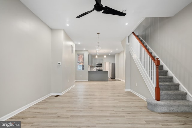 unfurnished living room featuring light hardwood / wood-style floors and ceiling fan