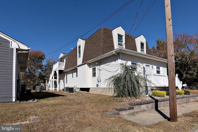 view of property exterior with a lawn and central AC