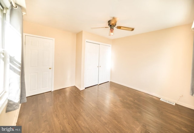 unfurnished bedroom featuring dark hardwood / wood-style floors, a closet, and ceiling fan