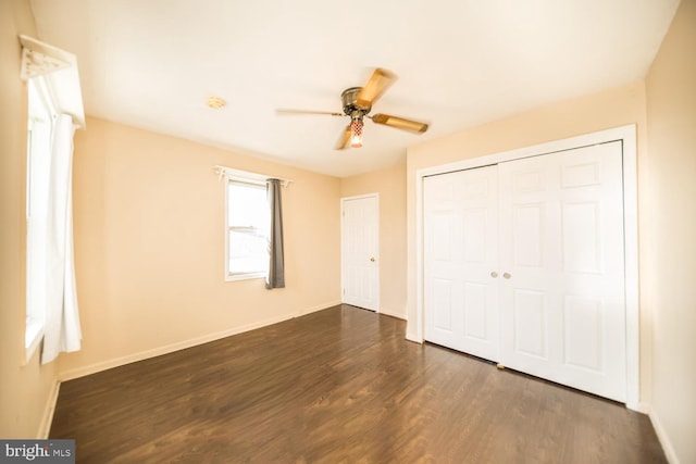 unfurnished bedroom with ceiling fan, a closet, and dark hardwood / wood-style flooring