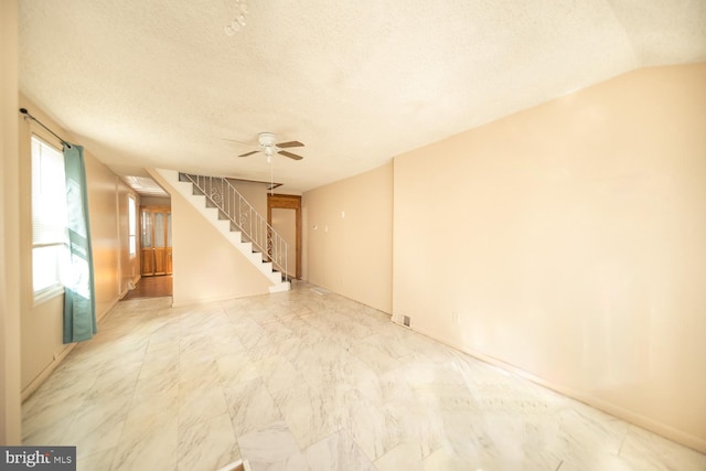 spare room featuring lofted ceiling, a textured ceiling, and ceiling fan