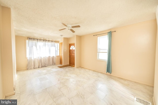 spare room with ceiling fan and a textured ceiling