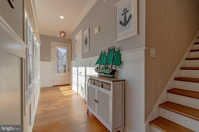 hallway featuring crown molding and light hardwood / wood-style floors