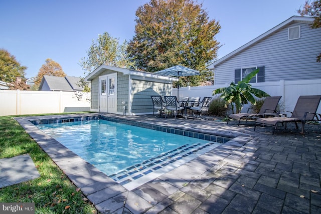 view of swimming pool with a patio and an outdoor structure