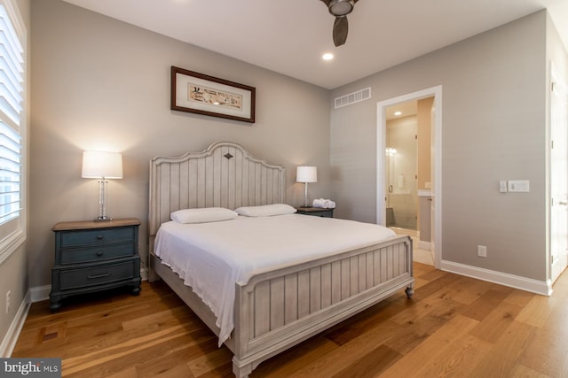 bedroom with light hardwood / wood-style floors, ensuite bathroom, and ceiling fan