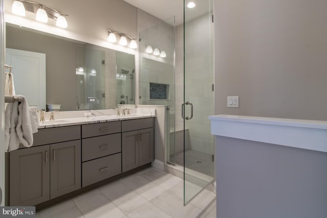 bathroom with a shower with door, tile patterned flooring, and vanity