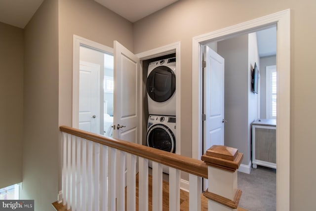 interior space featuring stacked washer / drying machine and carpet