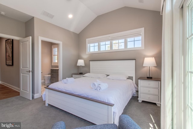 bedroom featuring lofted ceiling, ensuite bath, and carpet