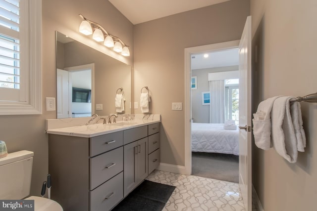 bathroom featuring toilet, vanity, and a wealth of natural light