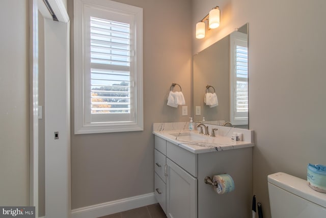 bathroom featuring toilet, vanity, and tile patterned flooring