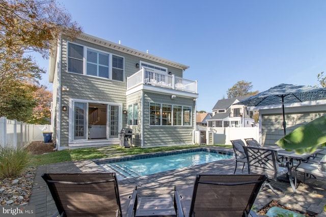 back of house with a patio, a fenced in pool, and a balcony