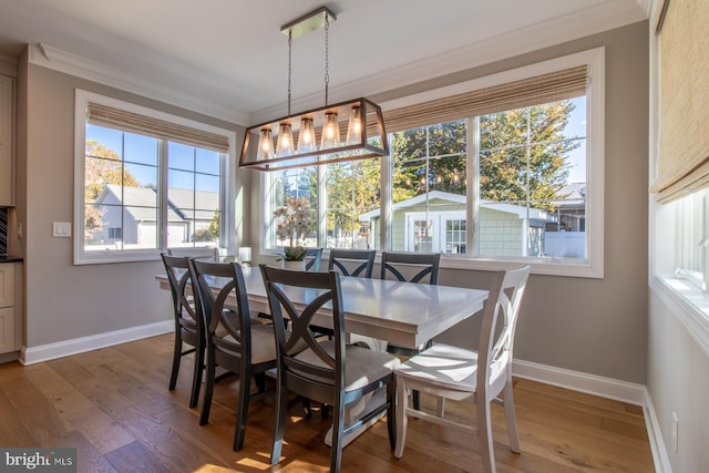 dining area with ornamental molding and hardwood / wood-style flooring