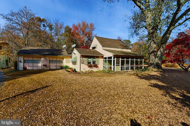 rear view of property featuring a sunroom