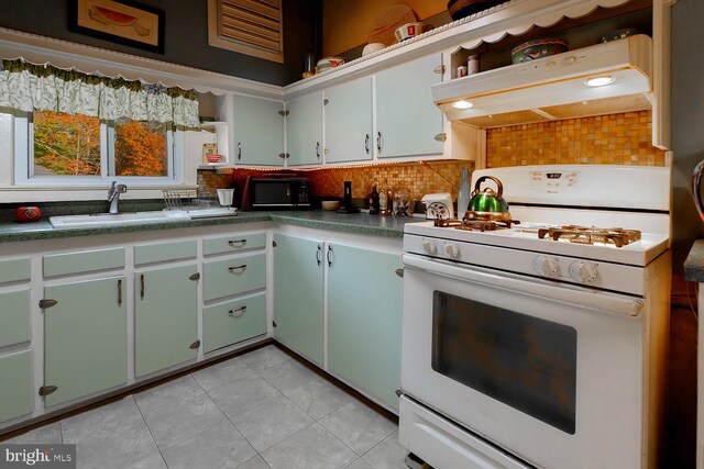 kitchen with premium range hood, tasteful backsplash, sink, white gas stove, and light tile patterned flooring