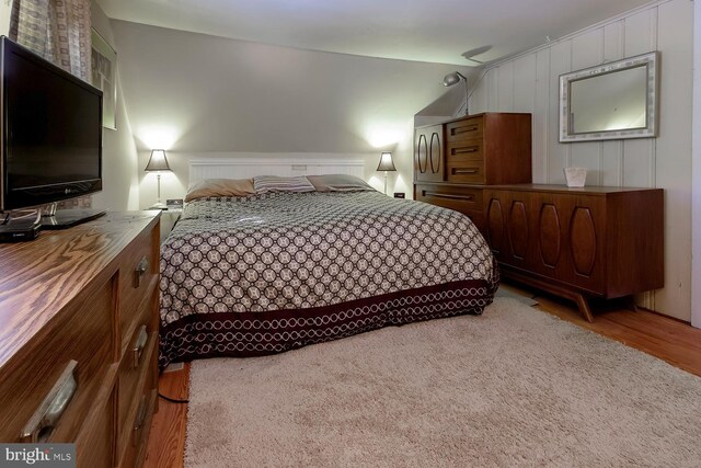 bedroom with light hardwood / wood-style flooring and vaulted ceiling