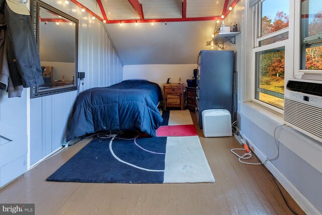 bedroom featuring hardwood / wood-style floors and vaulted ceiling