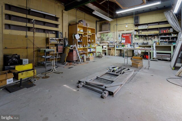 misc room with a workshop area and concrete floors