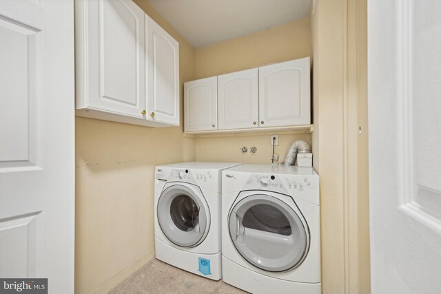 laundry area with separate washer and dryer and cabinets