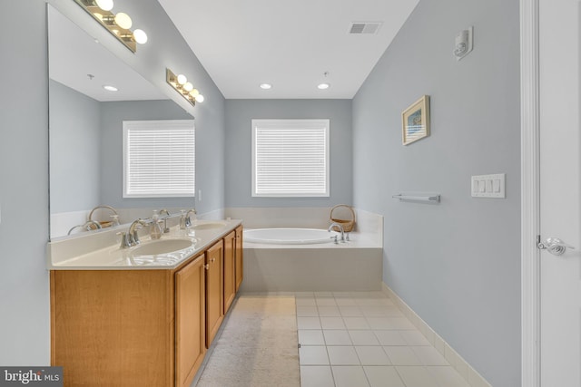 bathroom with vanity, tile patterned floors, and tiled tub