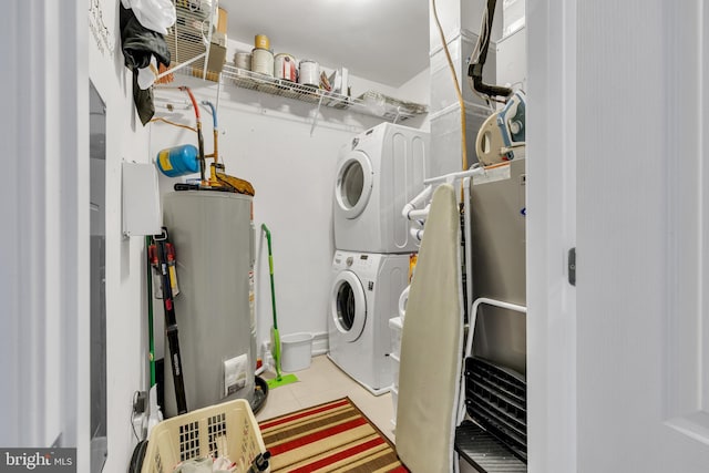 washroom featuring electric water heater, stacked washer and clothes dryer, and light tile patterned floors