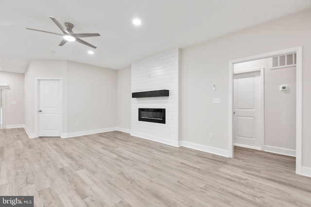 unfurnished living room featuring light wood-type flooring, ceiling fan, and a fireplace