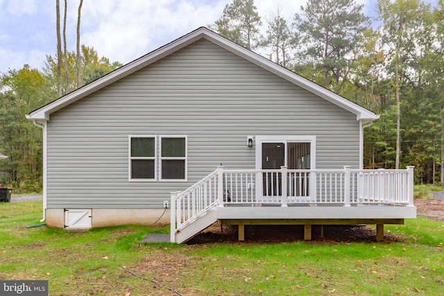 back of house featuring a lawn and a wooden deck