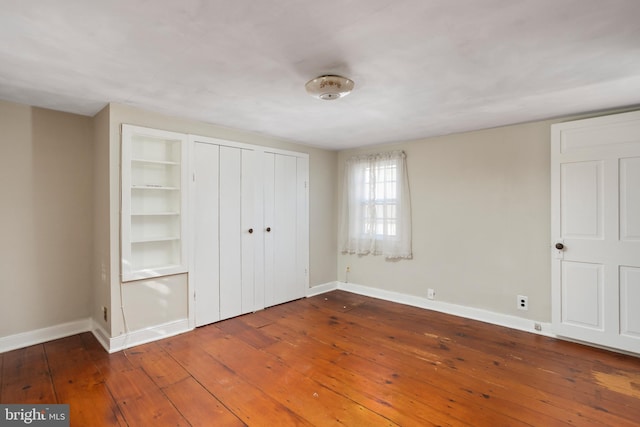 unfurnished bedroom featuring dark hardwood / wood-style flooring and a closet