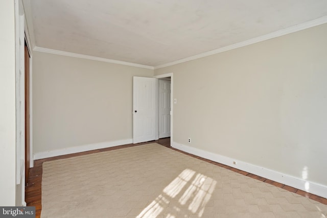 spare room with light wood-type flooring and crown molding