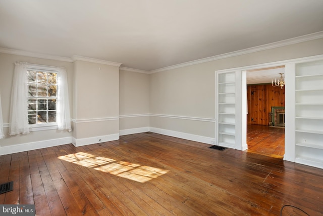 empty room featuring a fireplace, dark hardwood / wood-style flooring, and crown molding