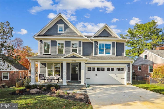 view of front of home featuring a front lawn, central air condition unit, a garage, and covered porch