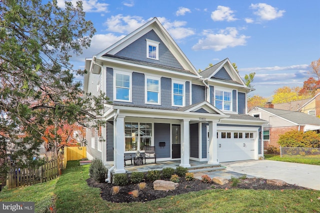 view of front of property with a front lawn, a garage, and covered porch