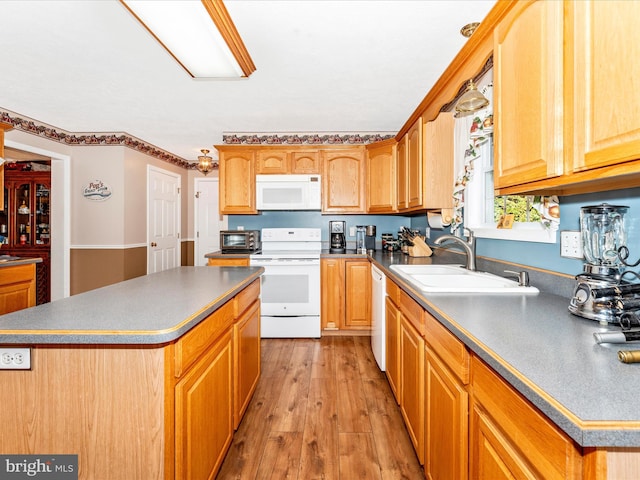 kitchen with a center island, white appliances, sink, and light hardwood / wood-style flooring