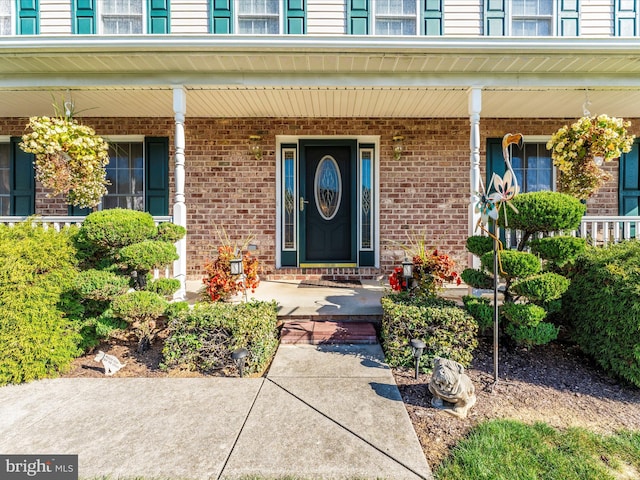 view of exterior entry featuring covered porch