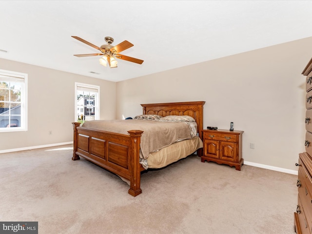 bedroom featuring light carpet, multiple windows, and ceiling fan