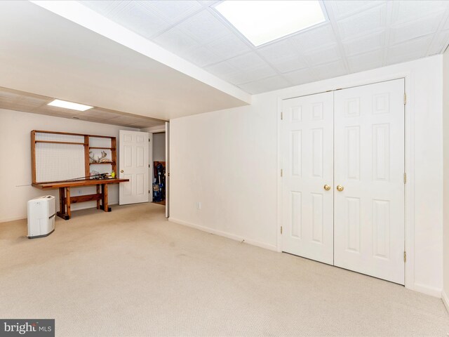 basement featuring light carpet