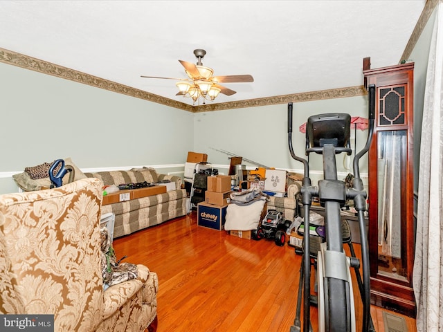 bedroom with ceiling fan, wood-type flooring, and crown molding