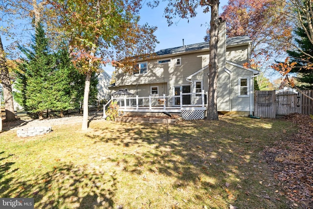 rear view of house featuring a yard and a wooden deck