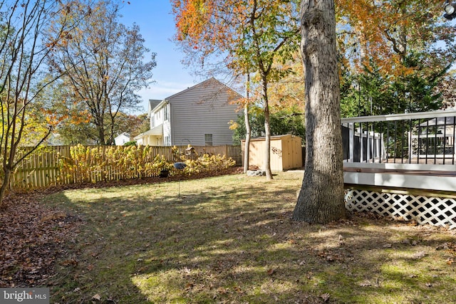 view of yard featuring a wooden deck and a shed