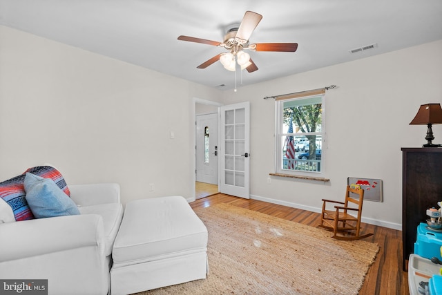 living room featuring hardwood / wood-style floors, french doors, and ceiling fan