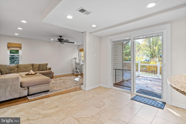 living room featuring ceiling fan and a healthy amount of sunlight