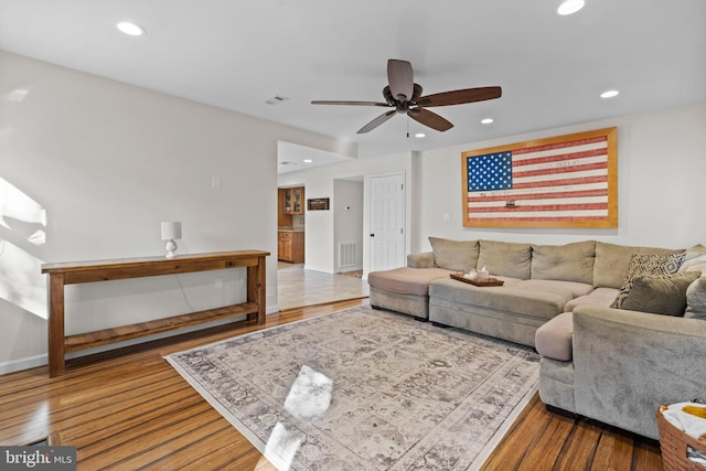 living room featuring hardwood / wood-style floors and ceiling fan