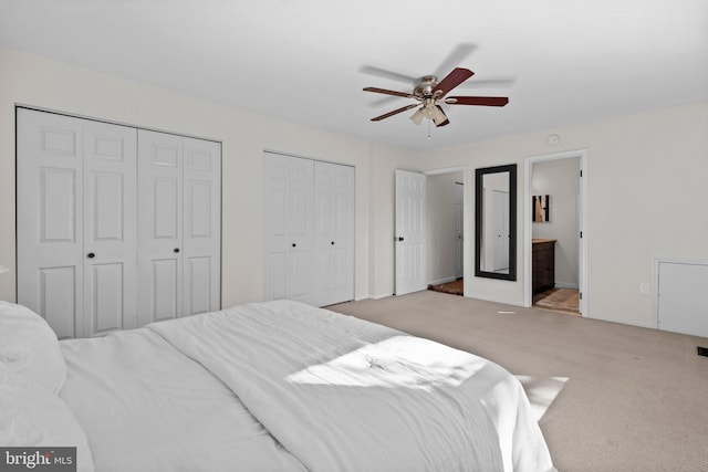 carpeted bedroom featuring ceiling fan, connected bathroom, and multiple closets